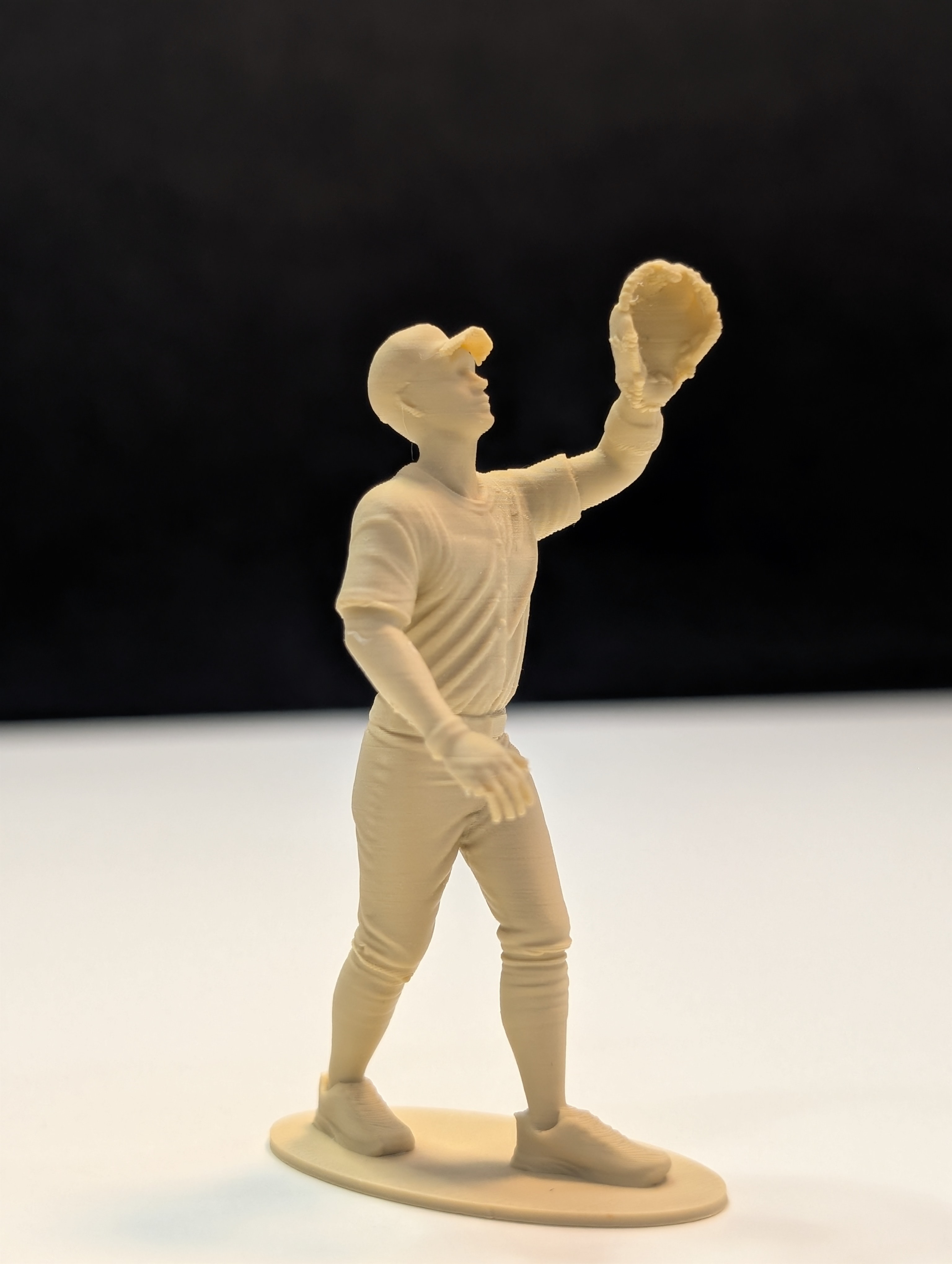 Outfielder figurine reaching up to make a catch